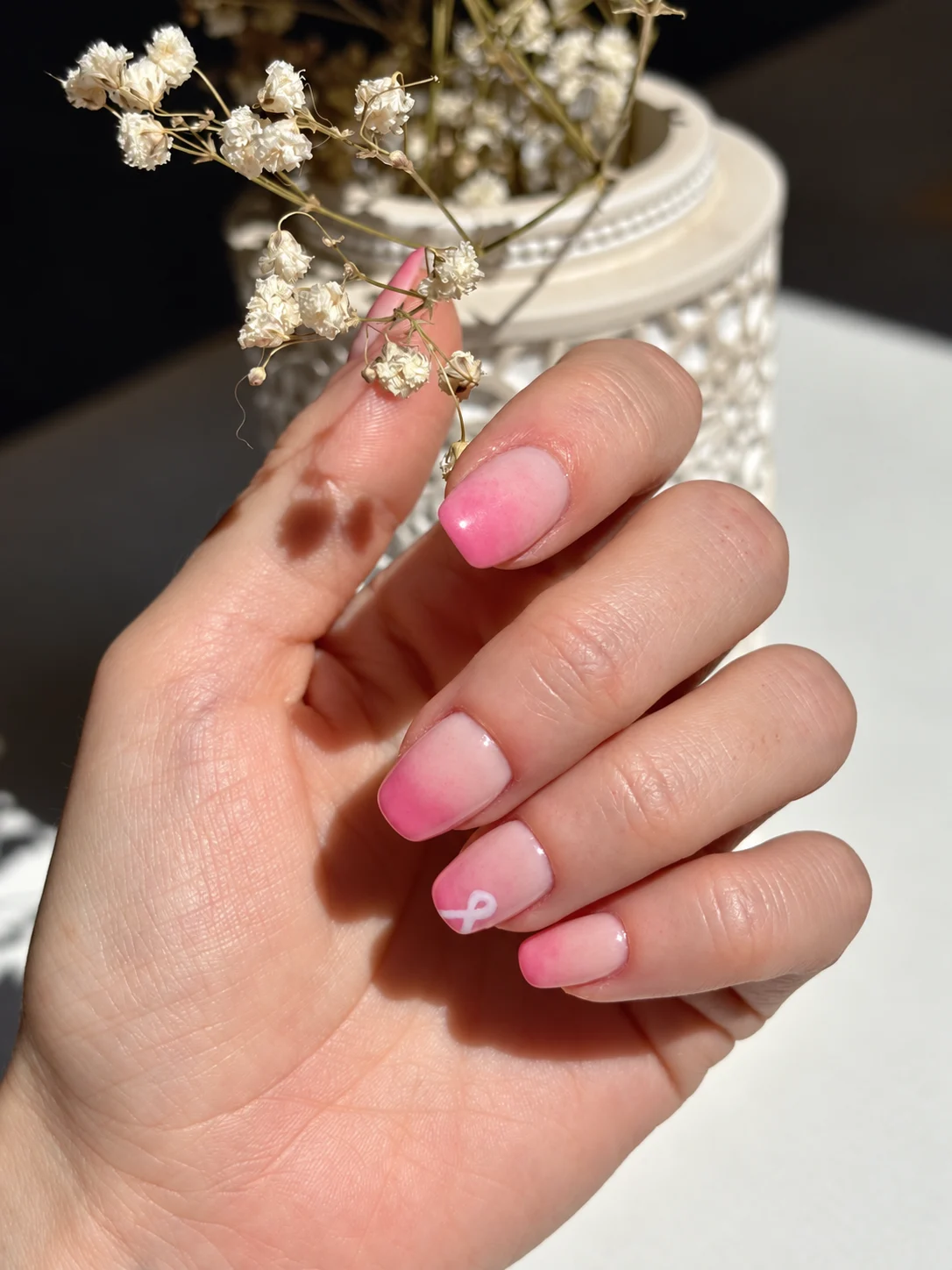 Pink ombré manicure with a white ribbon detail